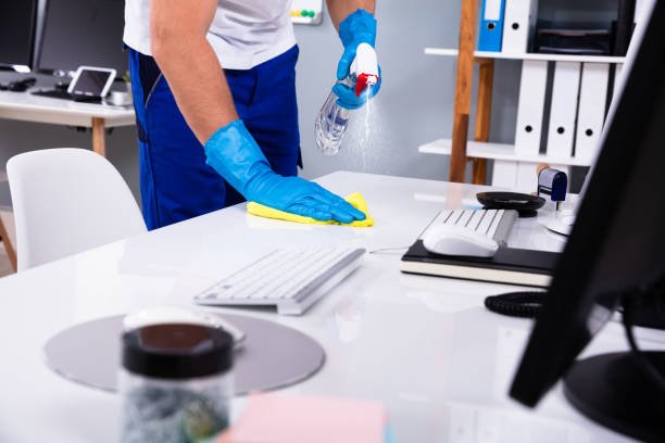 Janitor cleaning white desk in modern office in Calgary and Alberta