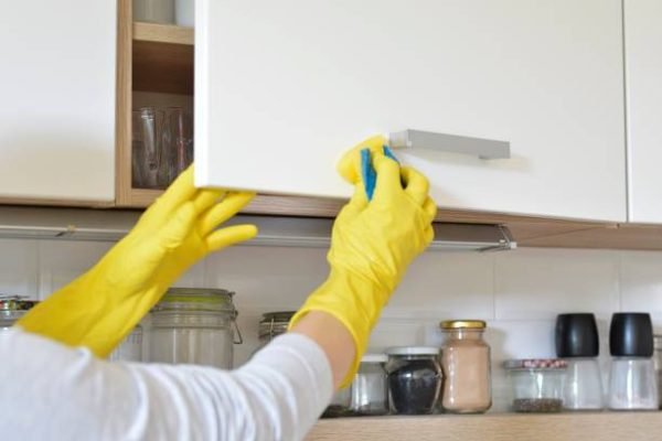 woman in yellow gloves refurbishing hardwood in Calgary
